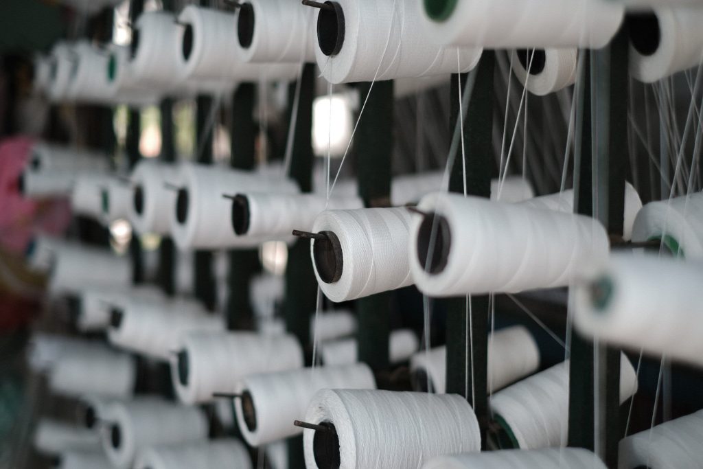 Giàn suốt sợi trắng xếp thành hàng trên khung creel